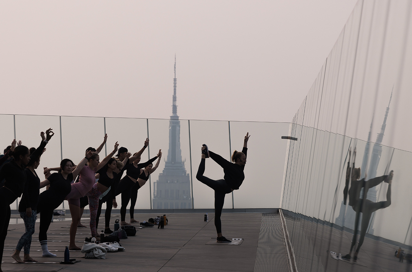 People attend a morning yoga class on top of a building in Manhattan, New York
