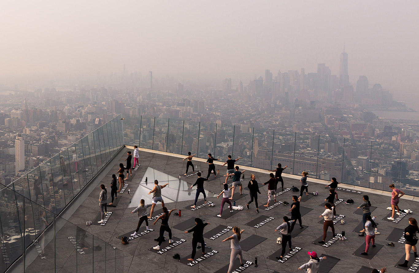 People attend a morning yoga class on top of a building in Manhattan, New York