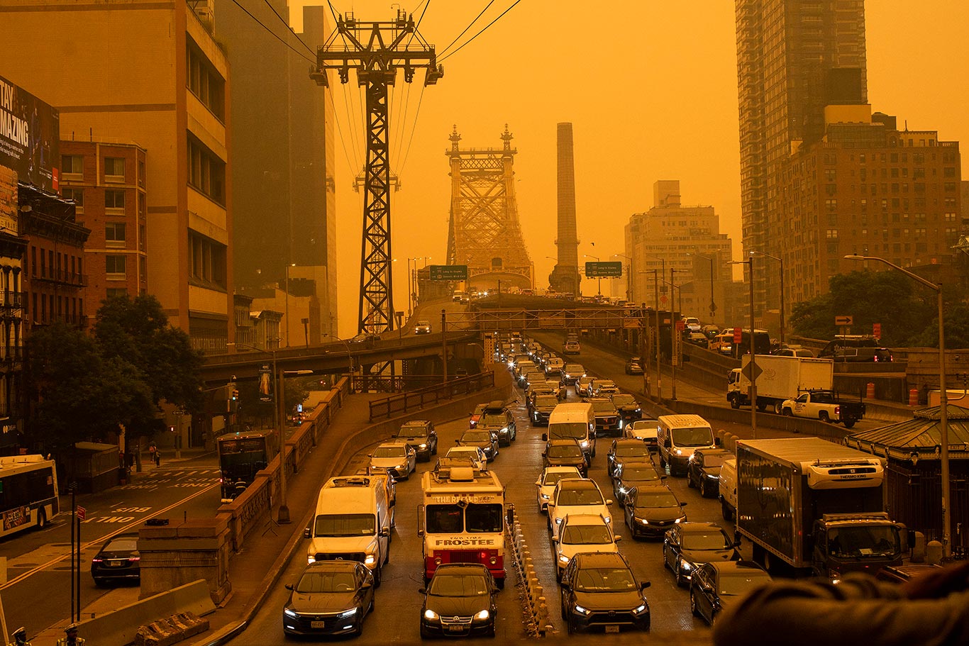 Traffic goes over the Ed Koch Queensboro Bridge in New York City as smoke from Canadian wildfires casts a haze over the area