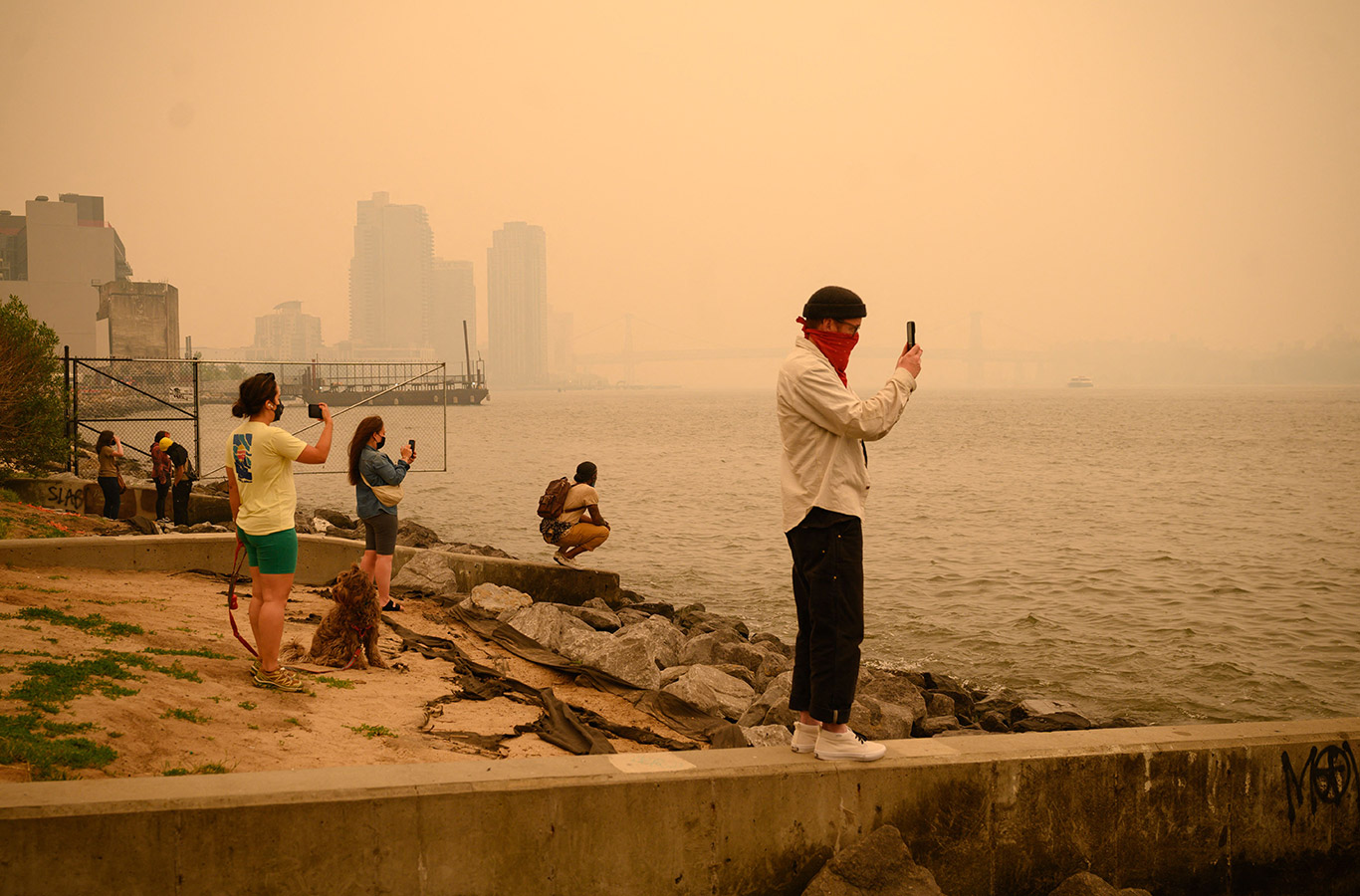 People take photos of the Manhattan skyline during heavy smog in New York