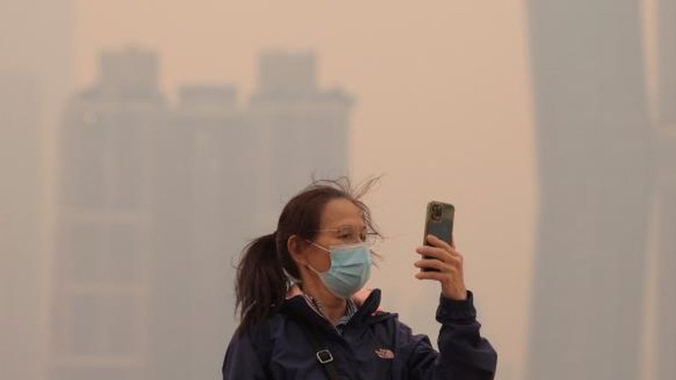 Image showing a woman using her phone in hazy conditions