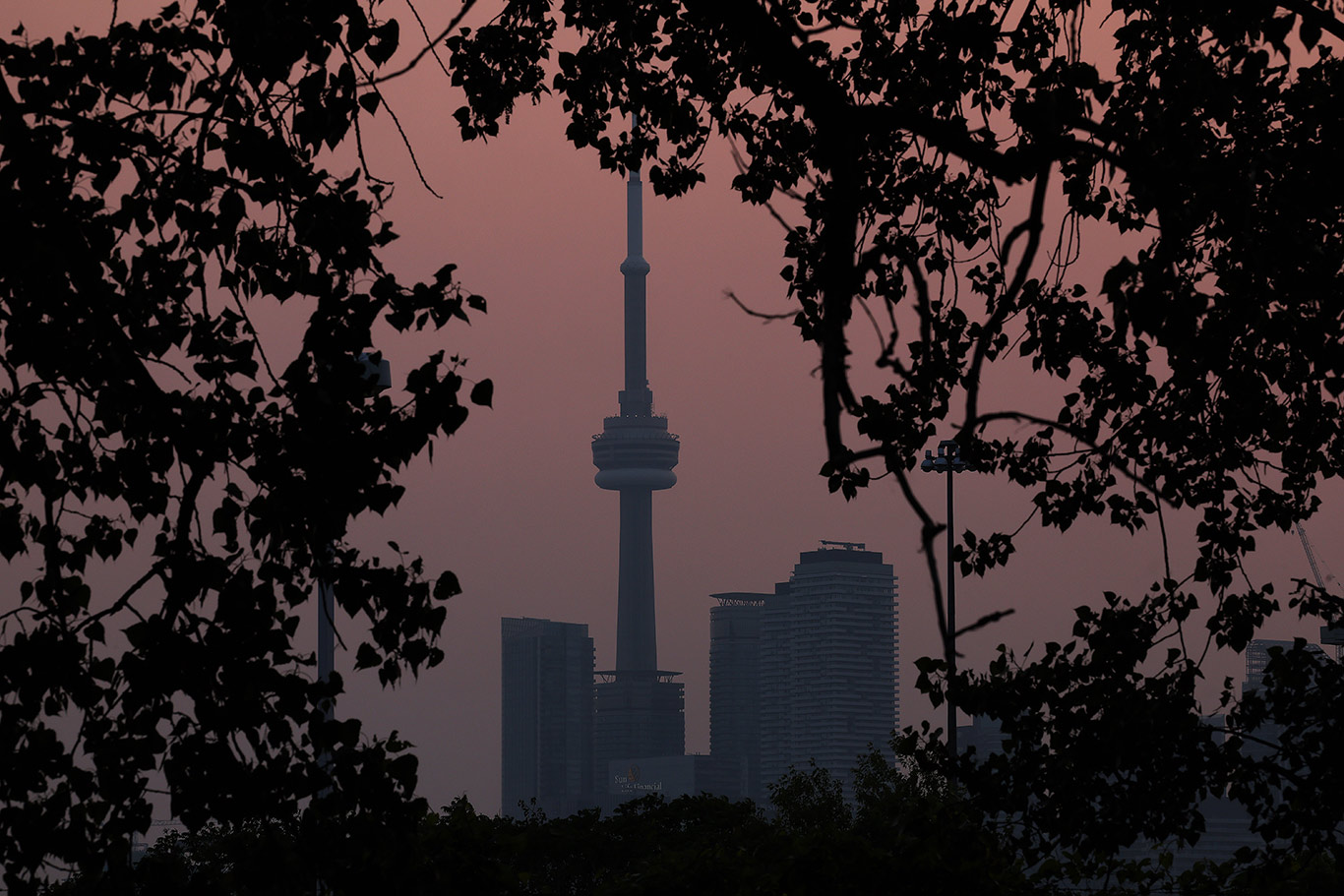 Smoke from forest fires creates a pink hazy sunset over Toronto